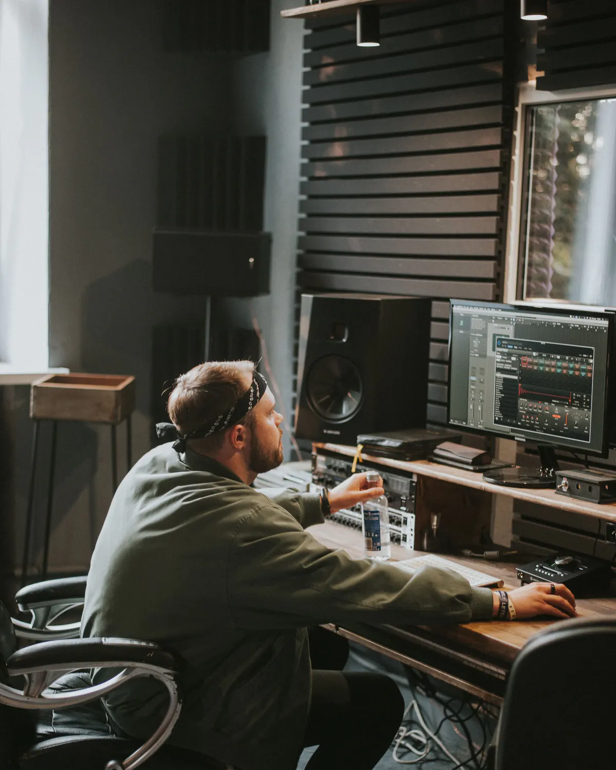 A producer working with audio software in a recording studio
